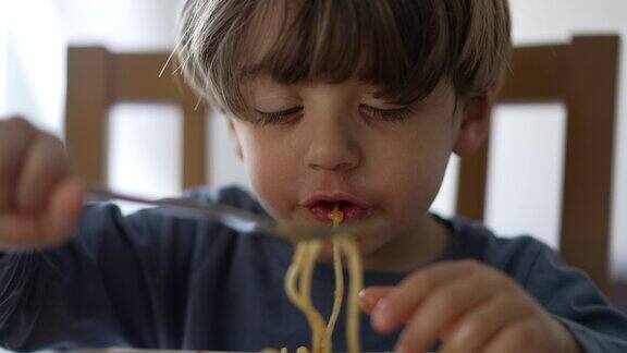 一个小孩用叉子自己吃意大利面孩子吃午餐