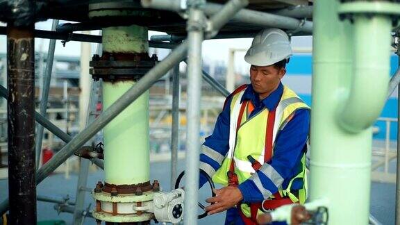 亚洲工人在大型炼油厂转动轮子