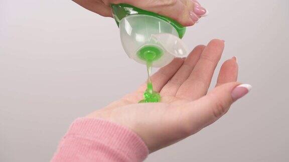 一个从瓶子里倒绿色洗发水到手上的特写