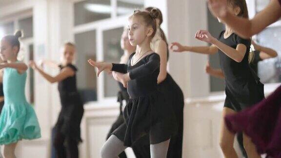 一群自信的孩子在舞蹈学校训练拉丁舞才华横溢的白人女孩和男孩在舞蹈工作室用慢动作排练技能和艺术概念