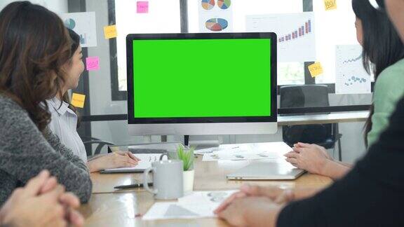 在一间会议室里4K商务人士正看着绿色屏幕的电脑显示器