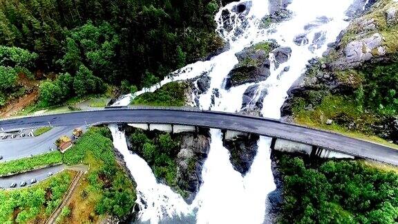 挪威Langfossen瀑布的航拍镜头和公路大桥上的汽车通过瀑布