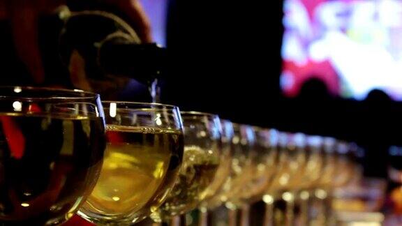 白葡萄酒倒进许多玻璃杯