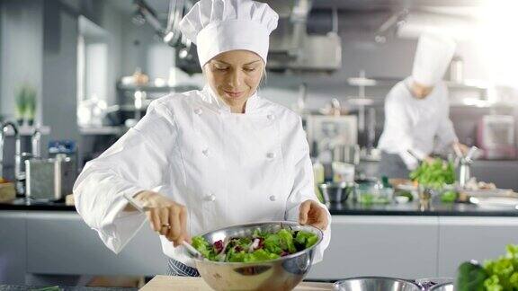 在一家著名的餐厅女厨师正在准备沙拉她在一家现代化的大厨房工作