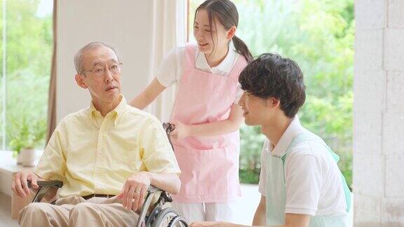 老人坐在轮椅上和护理人员在聊天