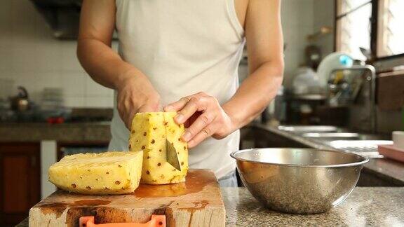 一个男人在厨房里切菠萝