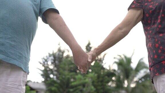 低角度亚洲华人老人手牵手分享亲密时刻在一起