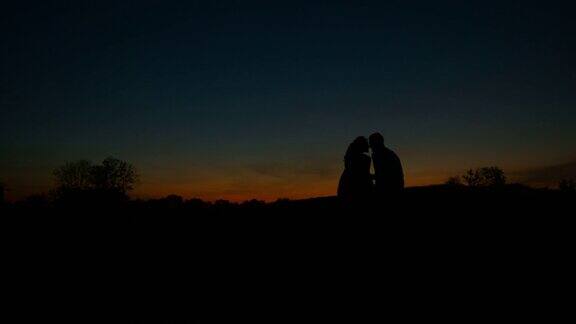 情侣拥抱在夕阳的背景