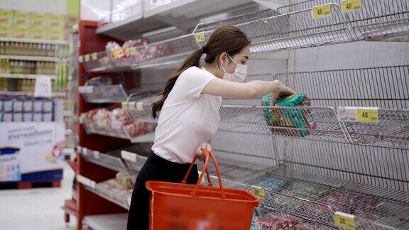 年轻妇女或女孩戴口罩在超市购买食品