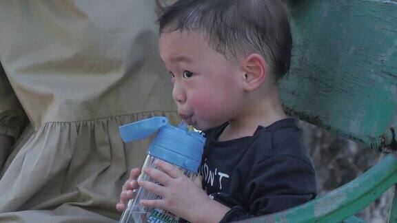 亚洲男孩喝水后他玩