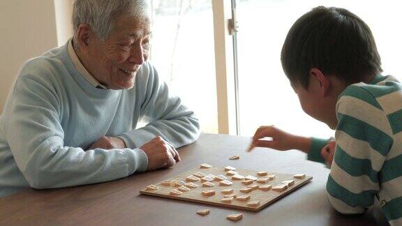 爷爷在家里和孙子下棋