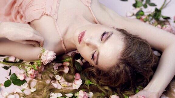 美丽的女孩躺在玫瑰中