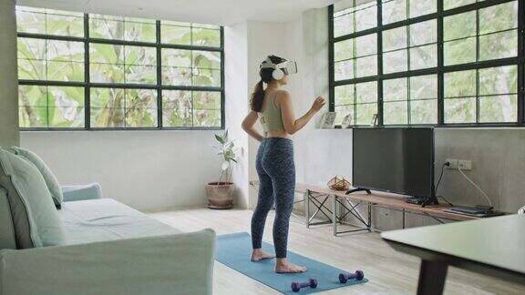 年轻女子在家里用虚拟现实头盔锻炼
