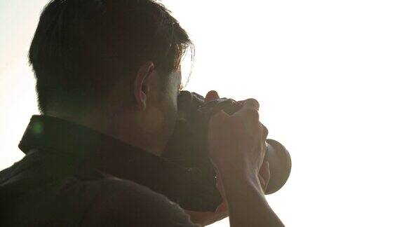 一名男子在日落时分用相机拍照