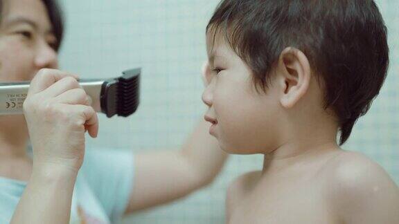 母亲在卫生间给儿子剪头发