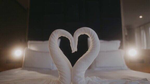 在浪漫的酒店房间床上叠成天鹅形的毛巾