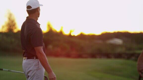白种男性高尔夫球手在日落时开球