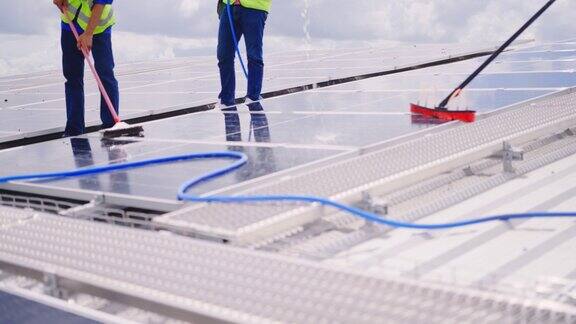 工人在工厂屋顶清洁太阳能电池板