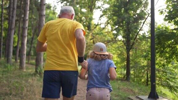 精力充沛的老人带着孙子在大自然的晨练路线上慢跑