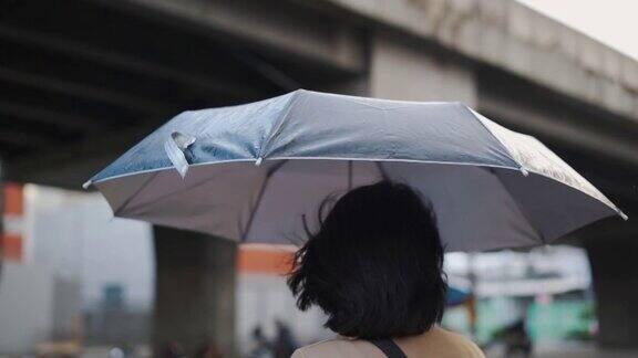 一个亚洲女人在雨中等出租车