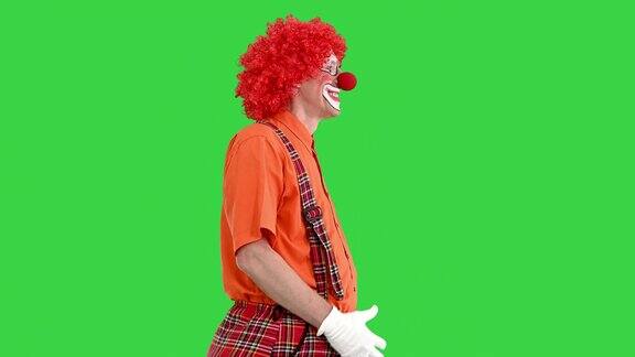 滑稽小丑红头发行走在绿色屏幕上色彩键滑稽