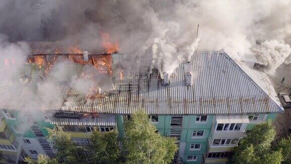 一幢高层住宅楼的屋顶起火浓烟滚滚俯视图