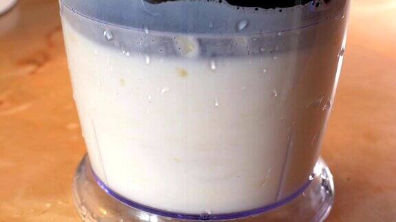健康牛奶有机奶昔香蕉冰沙的准备过程用搅拌机搅拌