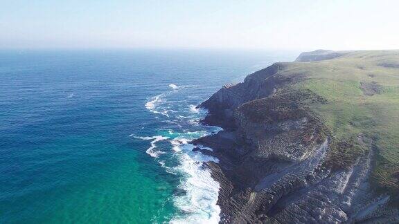 海浪冲击着绿色的悬崖在风景秀丽的海岸线景观在苏安斯坎塔布里亚西班牙