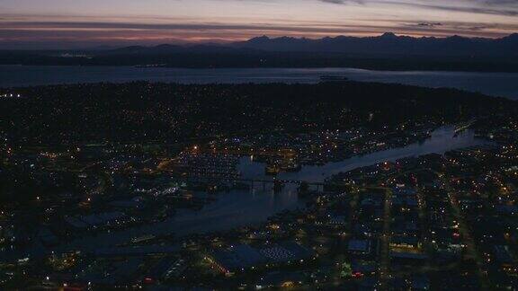 直升机鸟瞰图巴拉德桥锁木兰花西雅图景观夜晚灯光城市城市景观日落在奥林匹克山飞行