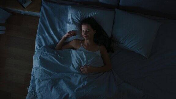 俯视图美丽的年轻女子舒适地睡在床上在卧室