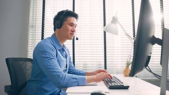 亚洲英俊的商务男子使用笔记本电脑在办公室工作Attractiveprofessionalmaleemployeeworkersittingontablefeelhappyandenjoyspendingleis