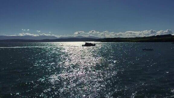 波光粼粼的海面上一艘救生艇的剪影