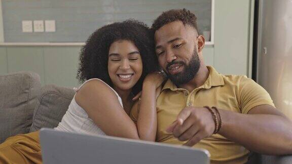 幸福的年轻夫妇在家里用笔记本电脑浏览网页愉快的男女朋友在社交媒体上聊天、拥抱在网上看电视剧享受周末的娱乐