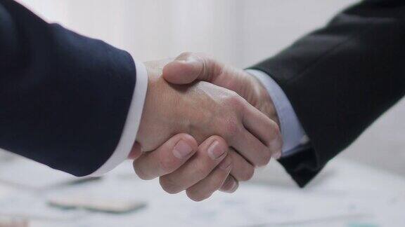 两个男性商业伙伴握手有利可图的协议合作
