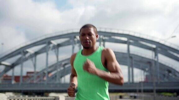 肌肉发达的非洲人在桥上跑马拉松训练正面视图腰部以上的镜头