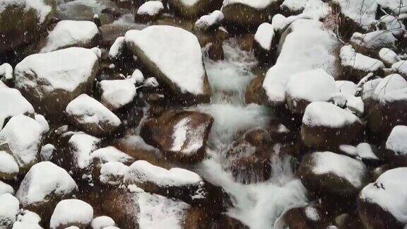 用慢镜头向下看雪花落在瀑布上然后向上倾斜