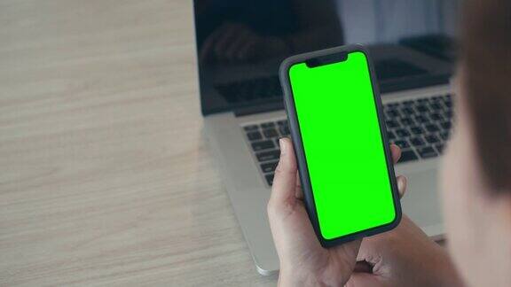 过肩拍摄的女性使用智能手机绿色屏幕