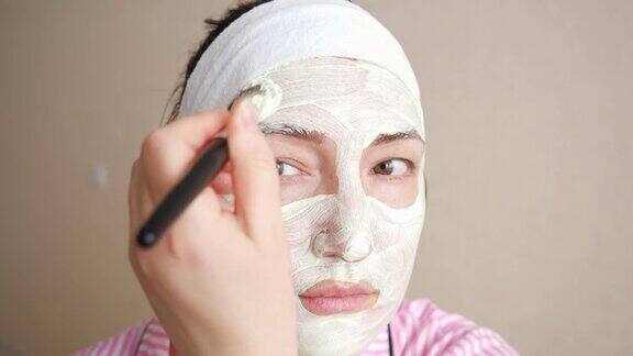 女人用刷子在脸上敷面膜