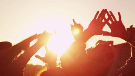 一群人在阳光下跳舞和举手慢动作镜头