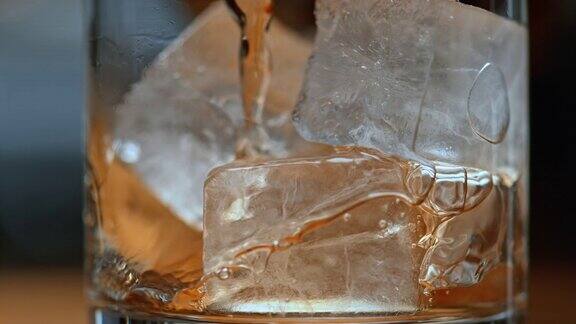 SLOMO将饮料倒入装有冰块的玻璃杯中