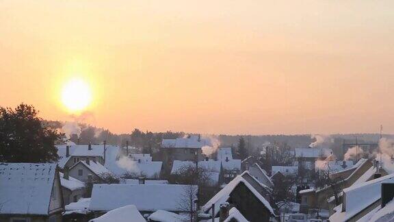 日出时分升起炊烟的雪景村庄