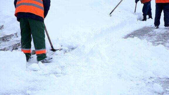 工人在冬天清扫道路上的积雪清理道路免受暴风雪