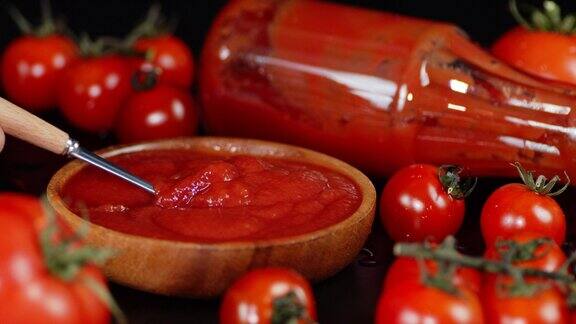用勺子在木碗里搅拌的番茄酱