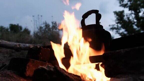 暮光之城的旅游营地老游客水壶站在篝火上