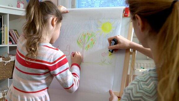 小女儿和她的妈妈正在用彩色铅笔画画