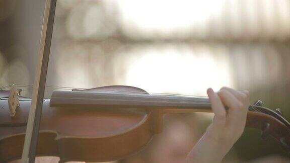 一个女人在拉小提琴小提琴家在拉她的手的特写