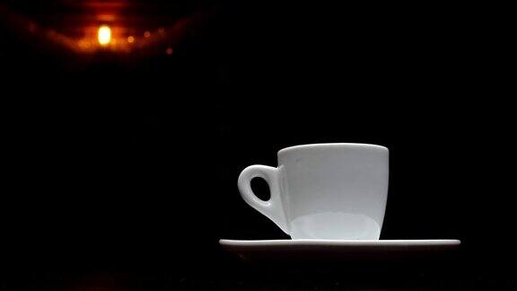 一杯热咖啡在一个黑色背景和一个台灯在背景4k分辨率