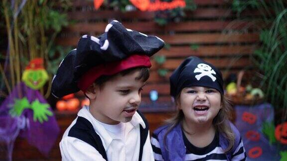 快乐的兄弟姐妹在万圣节穿着相配的海盗服装的肖像