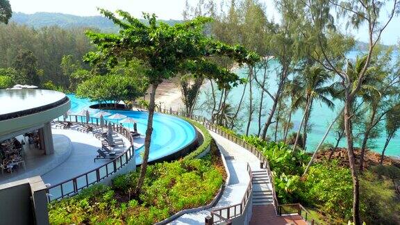 豪华的热带度假酒店海景旅游概念泰国旅游和暑假现代化的酒店设有游泳池和餐厅在海岸线上的绿色热带树木和海景