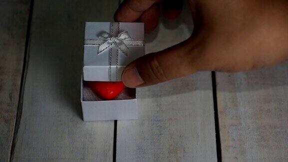 打开白色的礼盒里面有红色的心白色的木制背景